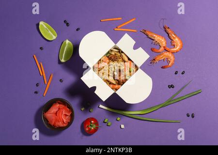 Composition de plat avec wok de nouilles et ingrédients sur fond violet Banque D'Images