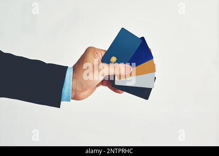 Vous n'aurez plus jamais besoin de transporter de l'argent. Studio photo d'un homme d'affaires non identifiable tenant une sélection de cartes de crédit sur fond blanc. Banque D'Images