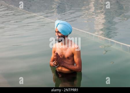 Pilgrim se baigner dans le bassin sacré Amrit Sarovar, Golden Temple, Amritsar, Punjab, India Banque D'Images