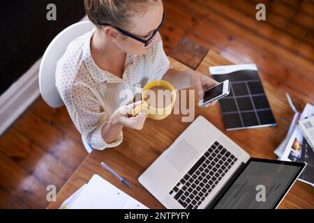 Pour bien entrer dans la journée, savourez une tasse de café chaud. Photo en grand angle d'une femme d'affaires qui boit du café tout en étant assise à son bureau. Banque D'Images