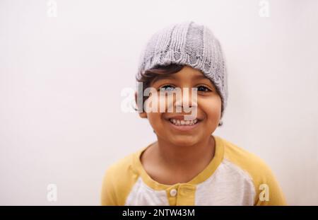 HES grandit vite. Photo d'un petit garçon mignon portant un bonnet. Banque D'Images