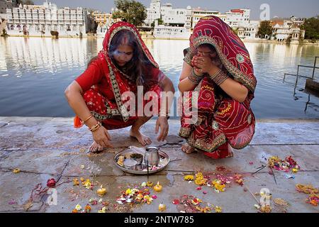 Pour prier, faire une vente de Gangaur ghat,lac Pichola, Udaipur, Rajasthan, Inde Banque D'Images