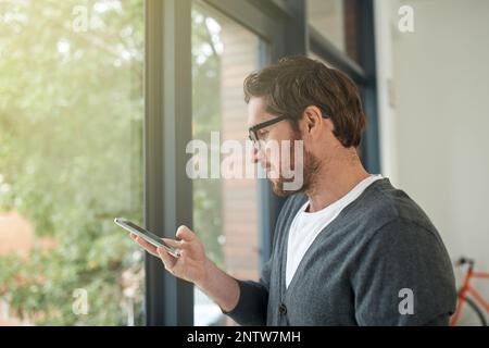 Restez connecté, restez informé. Photo d'un jeune entrepreneur utilisant un téléphone portable dans son bureau. Banque D'Images
