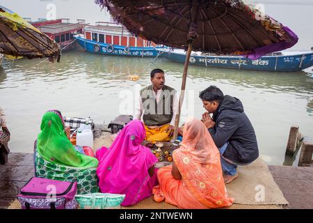 Pèlerins et un Pandit (prêtre et saint homme qui accomplit des cérémonies) à la tête d'un puja (prière), sur les ghats du Gange, Varanasi, Uttar Pradesh, en Banque D'Images