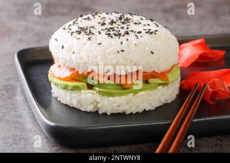 Hamburger de saumon à sushi sans gluten fait maison de style asiatique sur une assiette sur la table. Horizontale Banque D'Images