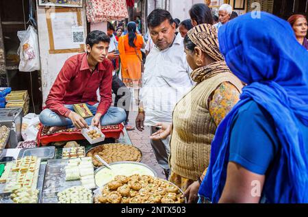 Man selling bonbons. Magasin de bonbons ou confiserie, à Gotam Nagar Street (rue principale),Centre Historique,Vrindavan, Mathura, Uttar Pradesh, Inde Banque D'Images