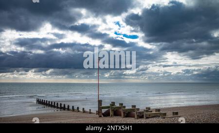 Un mouette se trouve au-dessus d'un poteau de marqueur de navigation attaché à une vieille groyne en bois sur la plage de galets de Bognor Regis, West Sussex, Royaume-Uni. Banque D'Images