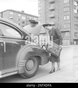 Dans le 1950s. Une femme photographiée en remplissant une voiture avec de l'essence d'une boîte dans la rue. Souvent une mesure drastique quand le réservoir est si vide il n'y a aucun moyen d'atteindre une station-service. Suède 1950 Kristoffersson réf. Z84-8 Banque D'Images