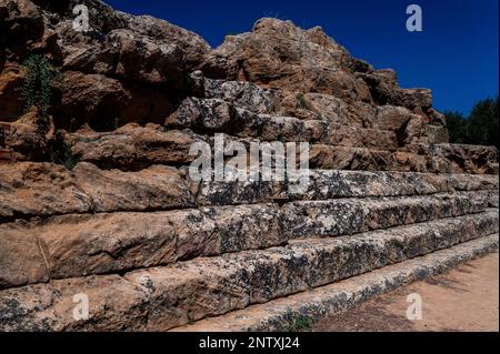 Les marches autour du périmètre du vaste temple grec ancien de Zeus Olympien dans la vallée des temples à Agrigente, Sicile, Italie, sont surmontées par des tas tumbres de blocs de pierre coupés et de tambours de colonne délogés par des tremblements de terre ou dans des guerres avec Carthage. Le temple Doric, l’un des plus grands du monde, a été construit autour de 480 av. J.-C. pour desservir la ville portuaire grecque d’Akragas. Banque D'Images