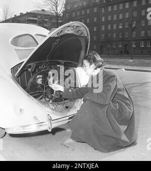 Dans le 1950s. Une femme photographiée à l'arrière de sa voiture Volkswagen Beetle ayant ouvert le capot exposant le moteur. Suède 1950 Kristoffersson réf. AX83-7 Banque D'Images