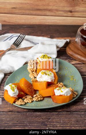 Dessert crémeux à la citrouille. Spécialités sucrées du ramadan turc. Dessert à la citrouille avec sorbet sur fond gris. Banque D'Images