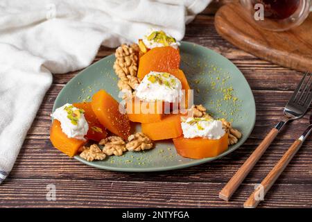 Dessert crémeux à la citrouille. Spécialités sucrées du ramadan turc. Dessert à la citrouille avec sorbet sur fond gris. Banque D'Images