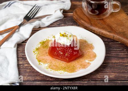 Dessert de coing avec sorbet sur fond gris. Dessert crémeux de coing. Spécialités sucrées du ramadan turc Banque D'Images