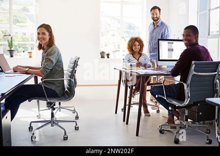 La disposition de nos bureaux améliore la productivité. Portrait d'une équipe de collègues travaillant dans un bureau à plan ouvert. Banque D'Images