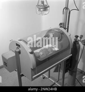 Nouveau-né en 1950s. Un nourrisson dans un incubateur de la maternité de Södersjukhuset Stockholm 1951. L'incubateur est un appareil utilisé pour maintenir des conditions environnementales adaptées à un nouveau-né. Banque D'Images