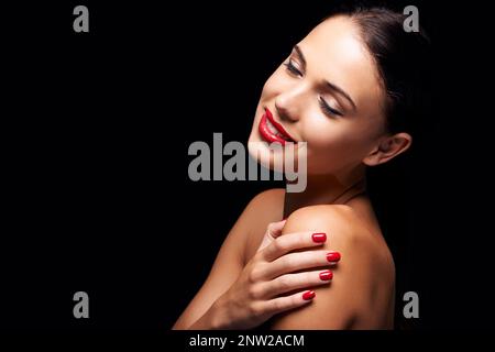 Rouge veineux. Une jeune femme aux lèvres et ongles rouges. Banque D'Images