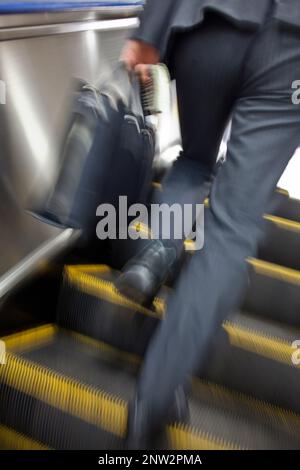Salaryman jusqu'escaliers mécaniques de la gare Shinjuku.Ligne Keio. Shinjuku, Tokyo, Japon Banque D'Images