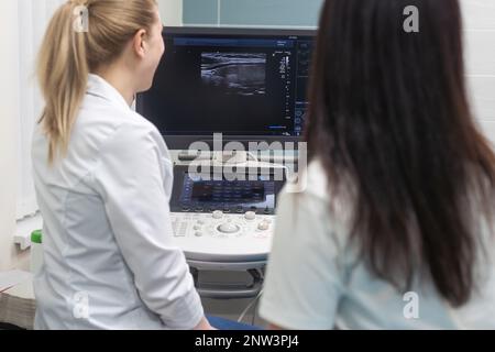 Smiling doctor, échographie. Le médecin effectue une échographie Banque D'Images