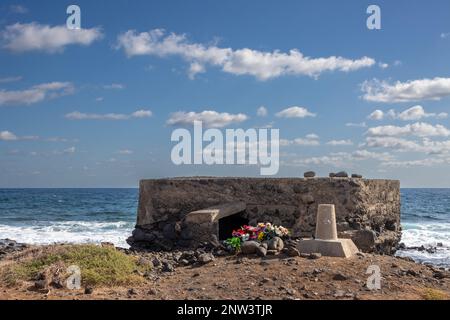 Bunker sur la côte est de l'océan Atlantique (côté Afrique). Mémoire encore vive, beaucoup de fleurs artificielles. Océan Atlantique et ciel bleu avec des nuages blancs. Banque D'Images