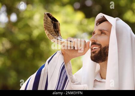 Homme juif dans la colonne soufflant shofar plein air. Célébration de Rosh Hashanah Banque D'Images