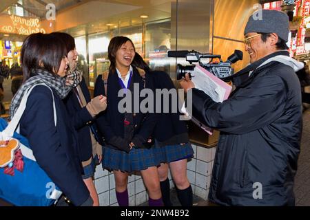 Shibuya.Man de filmer les jeunes filles, dans Hachiko square.La ville de Tokyo, Japon, Asie Banque D'Images