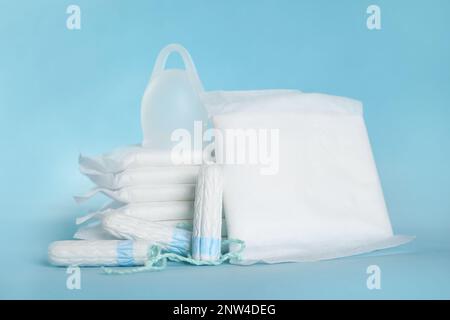 Coussinets et autres produits d'hygiène sur fond bleu clair Banque D'Images