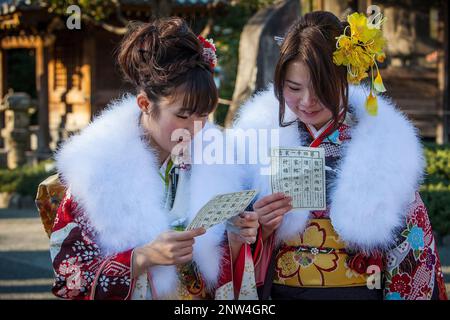 Les femmes en kimono furisode lire leur papier omikuji oracle, Seijin no hi, jour de célébration de l'arrivée de l'âge, le deuxième lundi de janvier, à Asakusa Banque D'Images