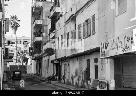 Sousse, Tunisie, 7 février 2023 : rue latérale d'une ville tunisienne avec immeubles d'appartements et façades altérées avec écaillage de la peinture, noir et blanc Banque D'Images