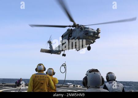 SAGAMI WAN, Japon (23 janvier 2023) Un hélicoptère MH-60R Seahawk, attaché à l'escadron de frappe maritime (HSM) 51, monte un tuyau JP-5 en préparation pour le ravitaillement en vol d'hélicoptère (HIFR) à bord du destroyer à missile guidé de classe Arleigh Burke USS Howard (DDG 83). Howard est affecté au Commandant de la Force opérationnelle (CTF) 71/Destroyer Squadron (DESRON) 15, la plus grande force de surface déployée à l’avant de la Marine et la principale force de surface de la flotte américaine 7th Banque D'Images