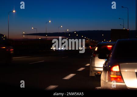 Les voitures de nuit se bloquent à la sortie de l'autoroute. Vue des véhicules du point de vue du conducteur Banque D'Images