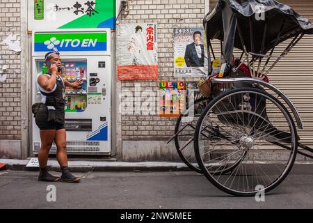Rickshaw parlant au téléphone, dans 2 chome street,à côté de Temple Sensoji, Asakusa, Tokyo, Japon, Asie Banque D'Images