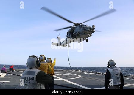 SAGAMI WAN, Japon (23 janvier 2023) classe 1st du compagnon de Boatswain Isiah Gueta, de San Diego (Californie), et Robert Kennedy, maître du chef du compagnon de Boatswain, de ft. Lauderdale, Floride observez la sécurité du ravitaillement en vol par hélicoptère (HIFR). Le compagnon 2nd de Boatswain Anthony Rodriguez, de Tyrone, en Pennsylvanie, et le compagnon 2nd de Boatswain Aaron Marshall, de ft. Worth, Texas, signale le positionnement de l'hélicoptère comme un signaleur d'atterrissage enrôlé (LSE) à bord du destroyer de missile guidé de classe Arleigh Burke USS Howard (DDG 83). Howard est affecté au commandant de la Force opérationnelle (CTF) 71/Destr Banque D'Images