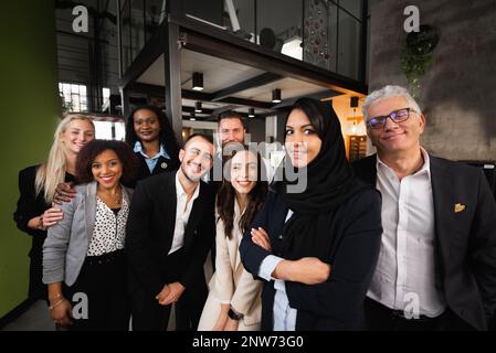 Portrait d'un grand groupe de travail avec une origine ethnique et un âge divers regardant la caméra sourire. Banque D'Images