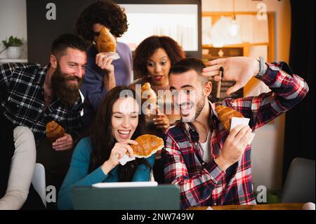 Groupe de jeunes collègues ou étudiants utilisant un ordinateur portable et s'amuser pendant une pause. Banque D'Images