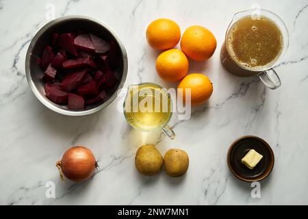 Ingrédients de la soupe à l'orange et aux betteraves oignon et pomme de terre. Les ingrédients principaux sont l'orange et la betterave et le bouillon. Vous avez aussi besoin de beurre et de vin Banque D'Images