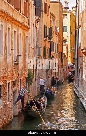 Gondoles traditionnelles avec des touristes sur des excursions le long de canaux étroits à Venise, Vénétie, Italie du Nord-est Banque D'Images