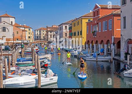Les touristes se sont empatés sur le canal Vena à Chioggia, petite île à l'entrée sud de la lagune vénitienne près de Venise, Vénétie, Italie du Nord Banque D'Images