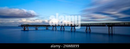 Une longue exposition panoramique d'un quai en bois qui s'étend jusqu'au loin à Sidney Pier, Sidney, C.-B., Canada Banque D'Images