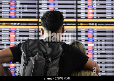 Bogota, Colombie, le mardi 28 février 2023. Un couple regarde les panneaux d'information de vol après que la compagnie aérienne à bas prix Viva Air ait suspendu ses activités à l'aéroport international El Dorado de Bogota, Colombie, le mardi 28 février 2023. La compagnie aérienne attend un processus d'intégration avec un groupe de compagnies aériennes qui doit être approuvé par les autorités aériennes colombiennes. Photo de: Cristian Bayona/long Visual Press Banque D'Images