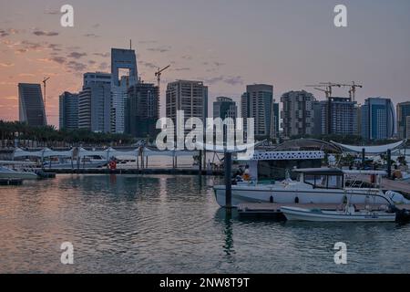 Lusail marina dans la ville de Lusail, Qatar coucher de soleil avec Yachts et bateaux avec drapeau du Qatar, horizon de Lusail et nuages dans le ciel en arrière-plan Banque D'Images