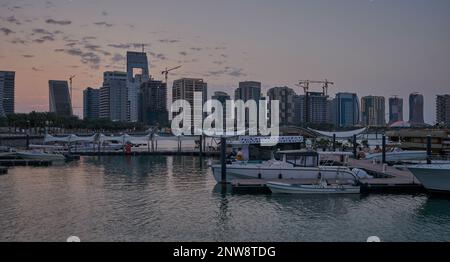 Lusail marina dans la ville de Lusail, Qatar coucher de soleil avec Yachts et bateaux avec drapeau du Qatar, horizon de Lusail et nuages dans le ciel en arrière-plan Banque D'Images