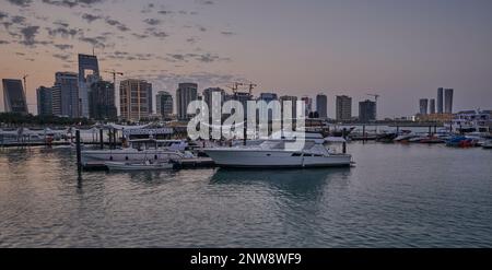 Lusail marina dans la ville de Lusail, Qatar coucher de soleil avec Yachts et bateaux avec drapeau du Qatar, horizon de Lusail et nuages dans le ciel en arrière-plan Banque D'Images