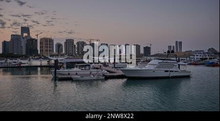 Lusail marina dans la ville de Lusail, Qatar coucher de soleil avec Yachts et bateaux avec drapeau du Qatar, horizon de Lusail et nuages dans le ciel en arrière-plan Banque D'Images