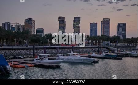 Lusail marina dans la ville de Lusail, Qatar coucher de soleil avec Yachts et bateaux avec drapeau du Qatar, horizon de Lusail et nuages dans le ciel en arrière-plan Banque D'Images