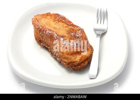 Torrijas. Typique espagnol sucré fait de pain frit trempé dans le lait avec la cannelle et le sucre sur un fond blanc. Typique de Pâques et de la semaine Sainte. Banque D'Images