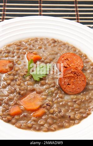 Lentejas con chorizo. Lentilles compotées avec de la saucisse rouge. Cuisine espagnole. Banque D'Images