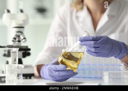 Scientifique femme tenant l'échantillon avec un liquide jaune Banque D'Images