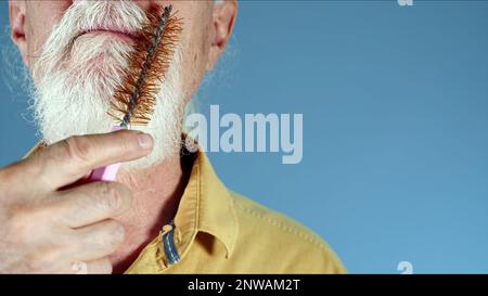 Le vieil homme peignant sa barbe blanche photo Banque D'Images