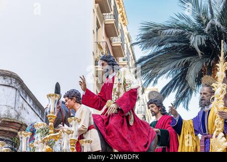 Le Christ est à cheval sur un âne dans le trône ou sur la plate-forme de la Fraternité de la Borriquita, en procession par les rues étroites de la ville Banque D'Images