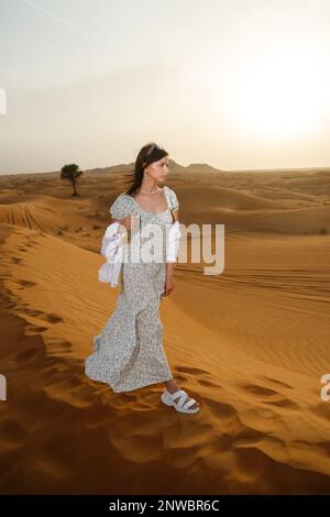 Une jeune belle femme posant dans une robe - sur le fond d'un paysage désertique. Banque D'Images